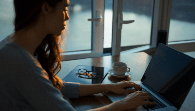 A woman working on a computer illustrates the online work that an agent will do for sellers.