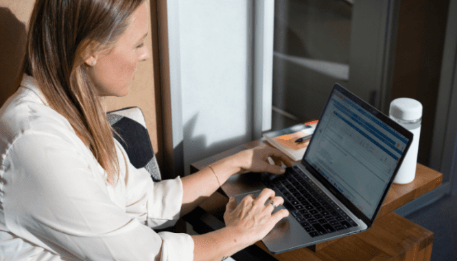 A woman looking at a due diligence real estate checklist on her computer.