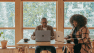 Two buyers using a computer to find an agent.