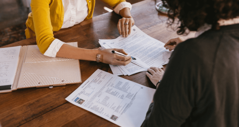 An agent and a homebuyer going over an exclusive contract with a real estate agent.