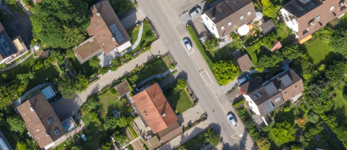 An aerial view of a suburban neighborhood with houses and gardens, taken from above, representing Top Agent Insights for Q1 2020